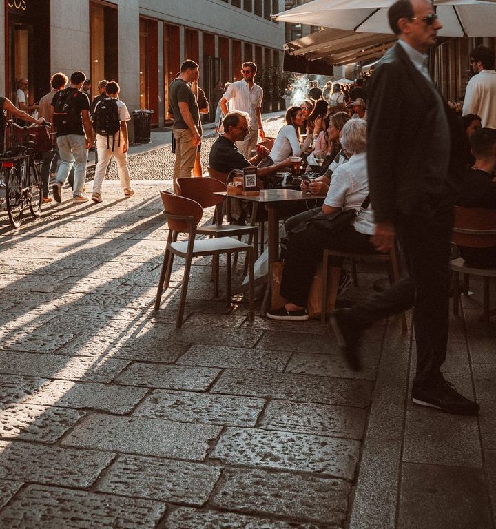 Tavolini all'aperto di un bar di Milano al tramonto